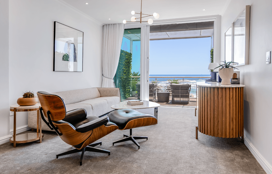Superior Sea-Facing Room lounge with Eames chair, ocean-view balcony and gold pendant chandelier