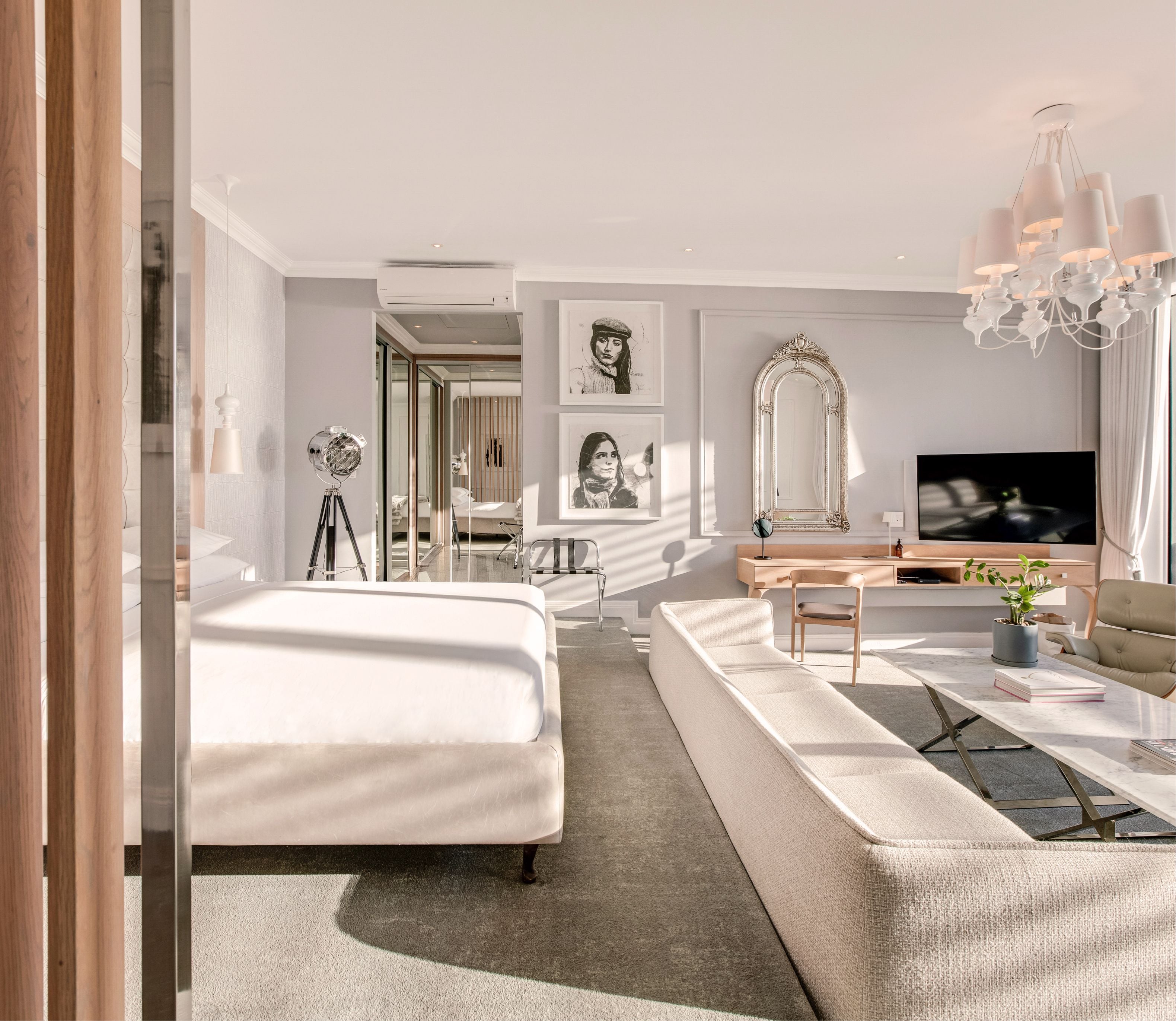 Deluxe Sea-Facing Suite lounge area at The Marly with plush sofa, marble coffee table, ornate mirror and wall-mounted TV