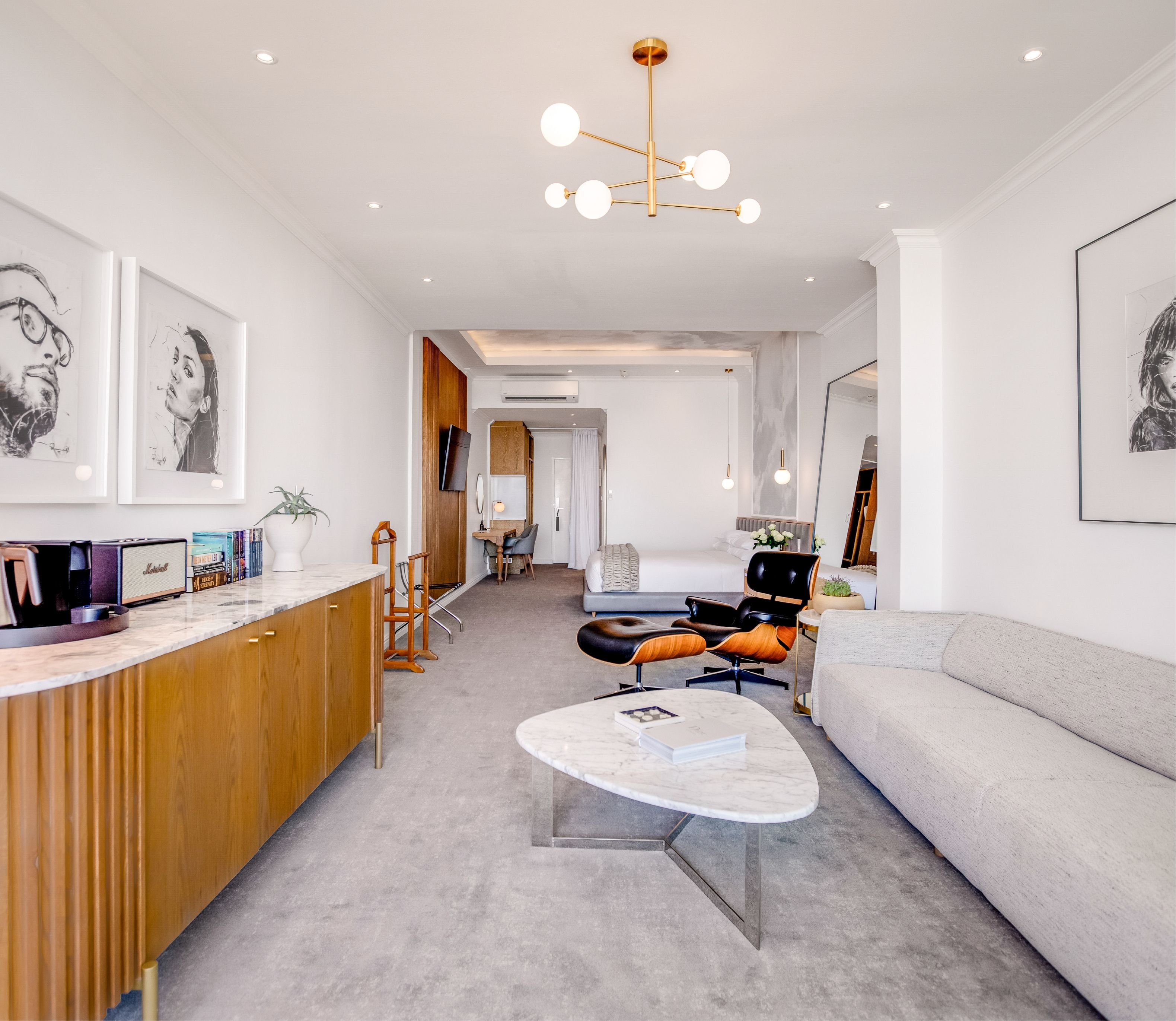 Superior Sea-Facing Room credenza styled with books, Marshall speaker and coffee station beneath framed portrait art